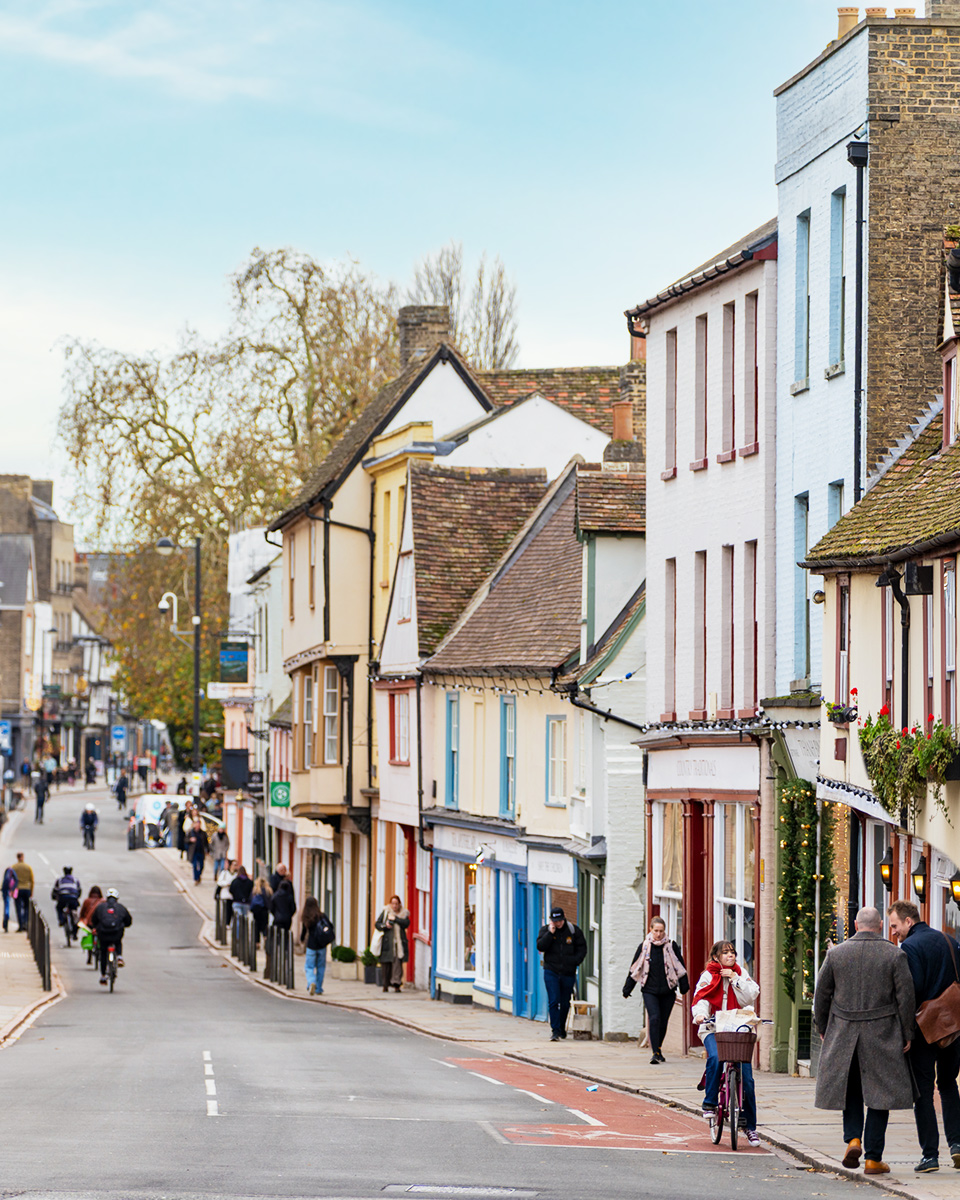 A photograph of the view down the Castle Street, the street lined with terraced houses and shops, and people walking