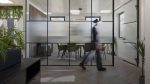 Woman walking past a meeting room glass wall at No. 7 Journey Campus