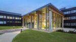 NIAB Exterior Building in Cambridge at dusk. Building entrance with internal lights on.